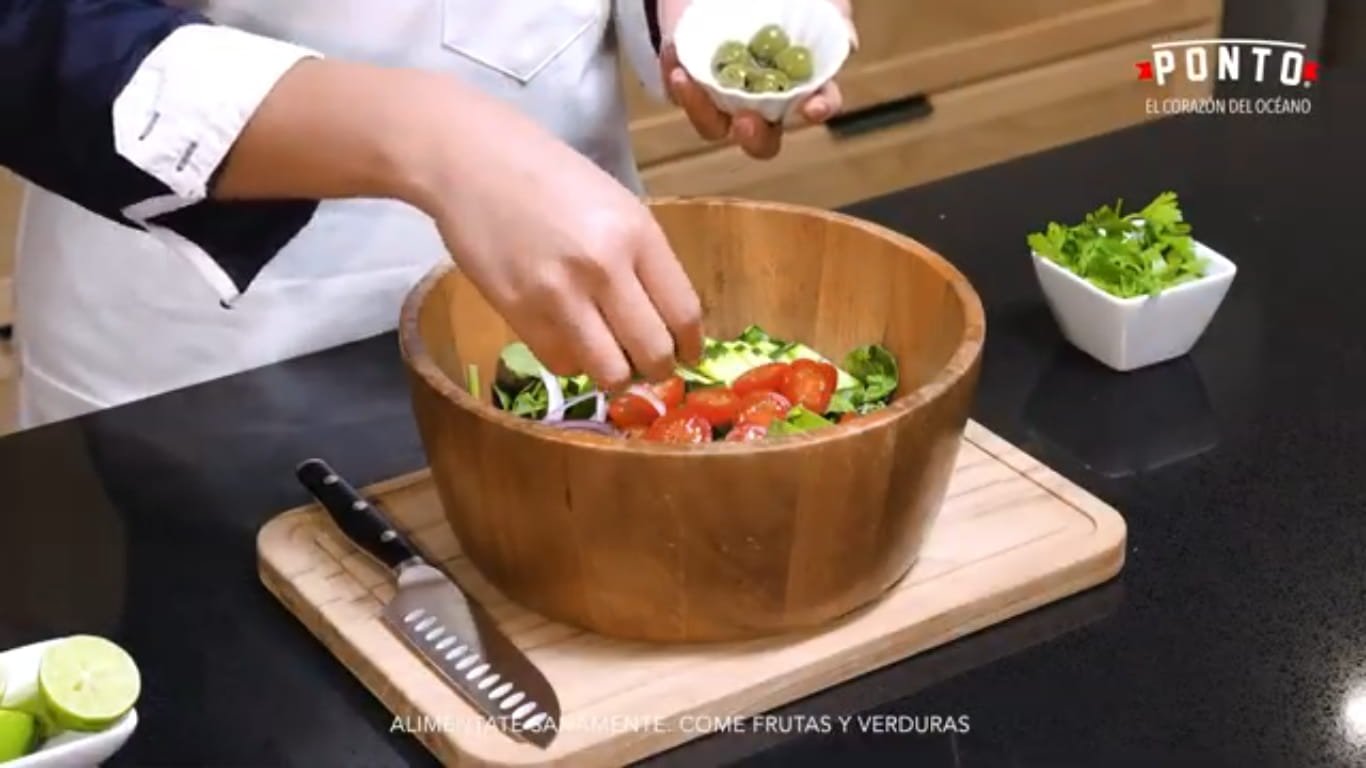 Integra las grasas saludables: Añade las rebanadas de aguacate y las aceitunas. Estos ingredientes ayudan a darle una textura cremosa y un sabor mediterráneo mucho más intenso.