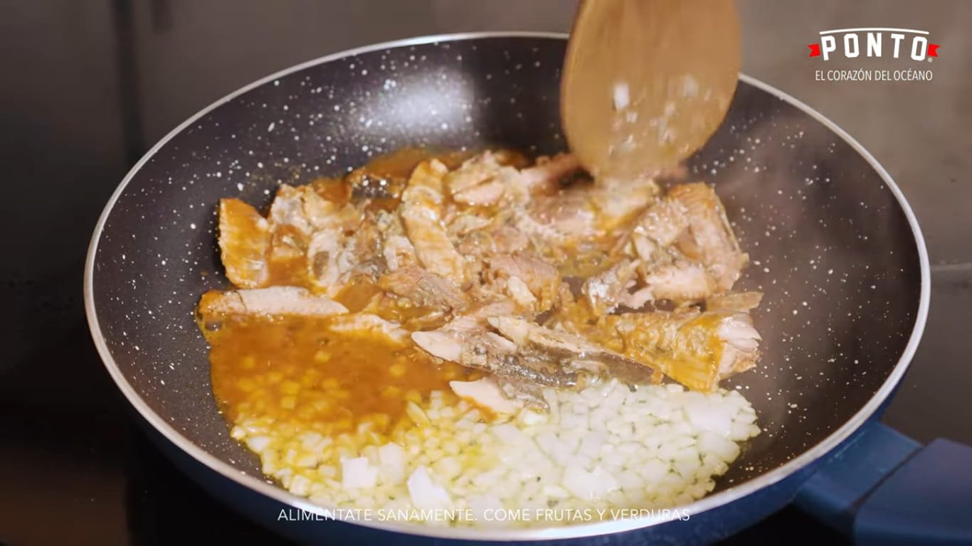 Prepara el relleno de sardinas: En un sartén, sofríe la cebolla picada hasta que comience a suavizarse. Agrega las sardinas Ponto en salsa de tomate y desmenúzalas ligeramente mientras se integran con la cebolla. Incorpora el cilantro picado y cocina durante unos minutos para que todos los sabores se mezclen.
