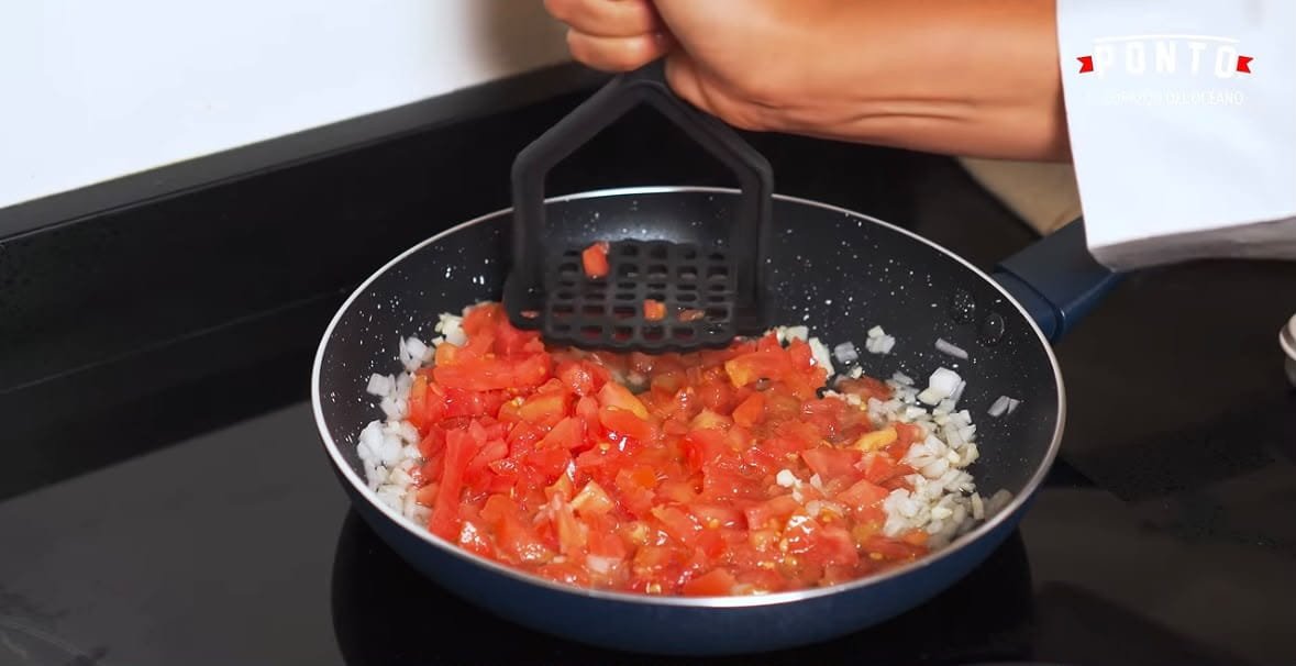 Prepara el guiso: Calienta un sartén con un poco de aceite y acitrona la cebolla junto con el ajo picado.<br> Agrega los tomates finamente picados y, con ayuda de un aplastador de papas, presiona ligeramente para que suelten sus jugos y formen una salsa suave.<br> Incorpora el pimiento morrón rojo picado y cocina unos minutos hasta que los ingredientes estén suaves y bien integrados.