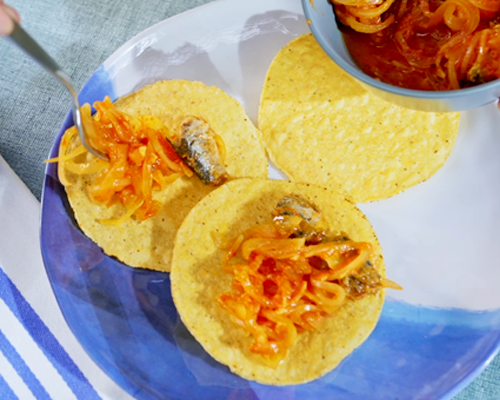 Montamos las tostadas de tinga con queso rallado, lechuga y crema.